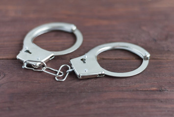a pair of handcuffs lying on an old wooden table