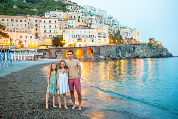 Fototapeta na wymiar Adorable little girl on sunset in Amalfi town in Italy