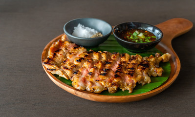 Grilled beef steak with spicy sauce on a wooden plate