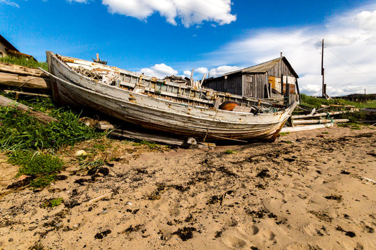 Old abandoned wooden boat on the beach in village Teriberka, Kola Peninsula, Russia