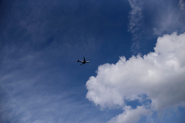 Fototapeta na wymiar airplane on background of blue sky with clouds