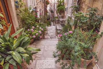 Fototapeta na wymiar Mediterranean summer cityscape - view of a medieval street with stairs in the Old Town of Dubrovnik on the Adriatic Sea coast of Croatia