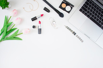 Women's fashion with tulips, laptop computers, perfumes, wristwatches and makeup brush tools on the White Blackground.