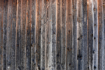Alte Holzwand mit vielen vertikalen hellen und dunklen braunen Brettern