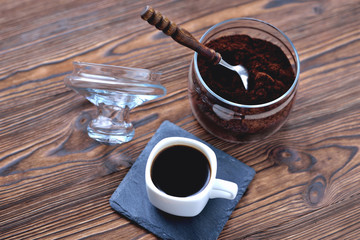 coffee in a cup on a stone stand ground coffee in a glass jar vintage coffee spoon, wooden natural...
