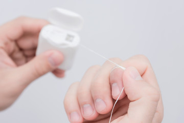Dental floss in the hands of man, man's hands, close up