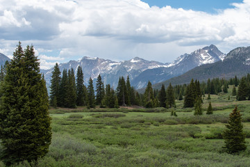Snow dappled San Juan Mountains, trees and meadow at Little Molas Lake in Colorado