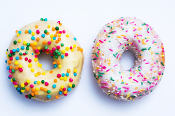 Two donuts with bright sprinkles, white background, food concept