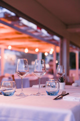 A glass of white wine on a table in a restaurant. Toned photo. Glare and light spots. Free space for text.