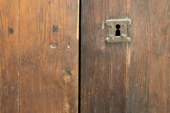 Rusted keyhole over an old wooden grunge door