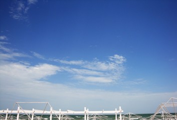 Red translucent matter against a sunny sky with white clouds