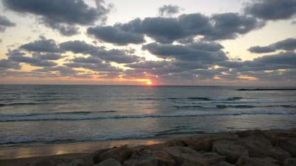 Sunset in the Mediterranean sea seen from Haifa's beach promenade, in Israel.