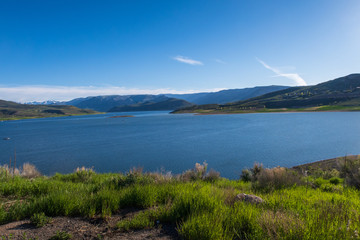 Landscape of Blue Mesa Reservoir with greenery and hills in the background near Gunnison, Colorado