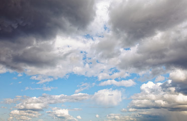 Naklejka na ściany i meble Summer dramatic clouds fly across a bright blue sky.