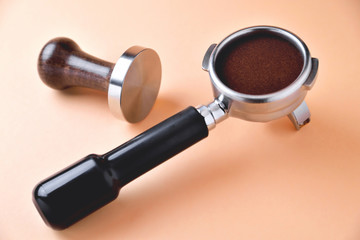 coffee horn with natural ground coffee and temper on an orange background
