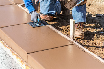 Construction Worker Using Stainless Steel Edger On Wet Cement Forming Coping Around New Pool