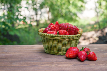 strawberries in a basket on a wooden background