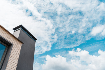 low angle view of new building against sky with clouds