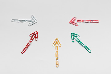 Many arrows pointing towards the center on white background, shot from above, closeup.