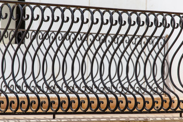 Black metal fence, closeup. Beautiful decorative cast iron wrought fence with artistic forging. Metal guardrail