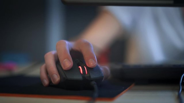 A man clicking digital mouse and working on computer. Close up hand on mouse. The concept of doing creative job. Computer lab. Cyber business. Real time shot