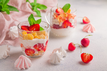 Whipped cream based strawberry dessert garnished with fresh mint leaves on a white background