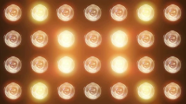 Wall of flashing lights and bright spotlights. Looped animations with glow and lens effects. Ideal background for video and music videos, for vibrant dynamic designs of composition from light