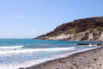 Beautiful view of the sea and mountains. Greek island of Santorini on a warm sunny day. Travel to the picturesque places of Europe. Cycladic islands in the Aegean Sea.