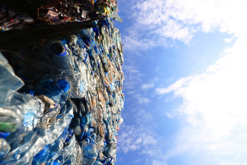 Compressed bales of plastic bottles ready for recycling against the blue sky
