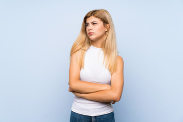 Teenager girl over isolated blue background holding copyspace imaginary on the palm to insert an ad