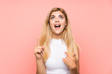 Teenager girl over isolated pink background with surprise facial expression