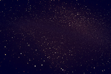 blackground of abstract glitter lights. blue, gold and black. de focused