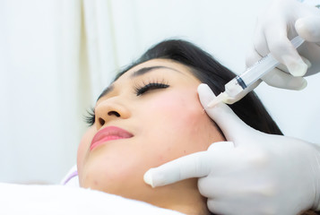 Naklejka premium A woman is doing cosmetic injection
