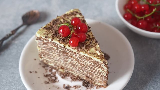 Red currant berries decorate a piece of pancake cake.