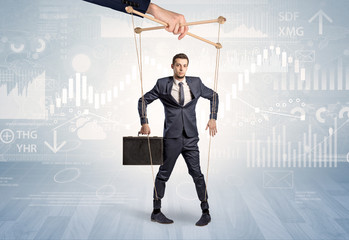 Puppet businessman controlled by another hand with financial concept