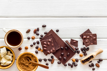 Different variety of chocolate and hazelnut on white wooden background top view space for text