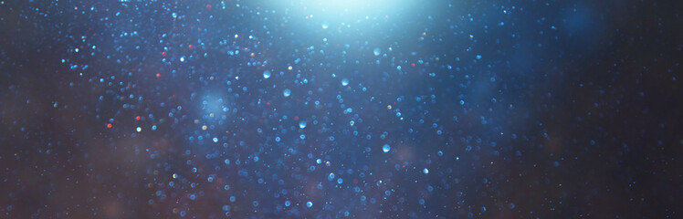 blackground of abstract glitter lights. blue, gold and black. de focused. banner
