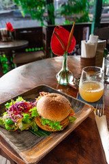 Board with tasty vegetarian burger on wooden table