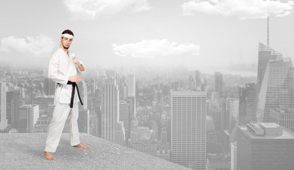 Young karate trainer doing karate tricks on the top of a metropolitan city