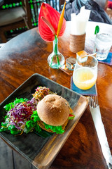 Fototapeta na wymiar Board with tasty vegetarian burger and vegetarian pasta on wooden table