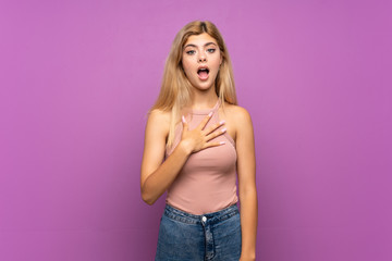 Teenager girl over isolated purple background surprised and shocked while looking right