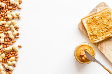 Make sandwiches with peanut butter in glass bowl on white background top view copyspace