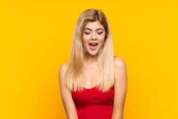 Teenager girl over isolated yellow background with surprise facial expression