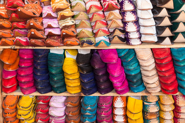 Morocco, Fes. Stacks of traditional shoes form a colorful pattern in this shop in the medina.