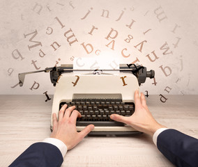First person perspective elegant hand writing on typewriter with flying letters concept