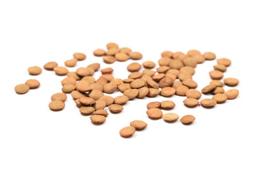 Isolated stack of uncooked lentils on white background from above.