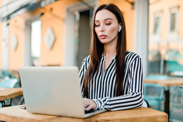 Obraz na płótnie Canvas woman using laptop sitting in cafe outdoors
