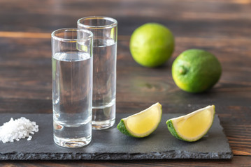 Glasses of tequila with lime wedges