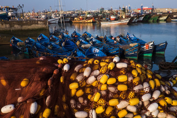 Morocco, Essaouira. A view of the port with fishing nets, boats and commercial vessels.