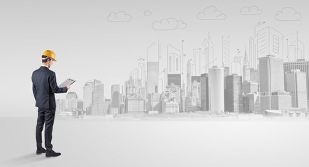 Young supervisor architect standing and replanning a big city panorama